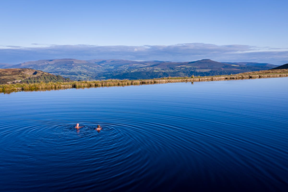 Two women wild swimming in a lake