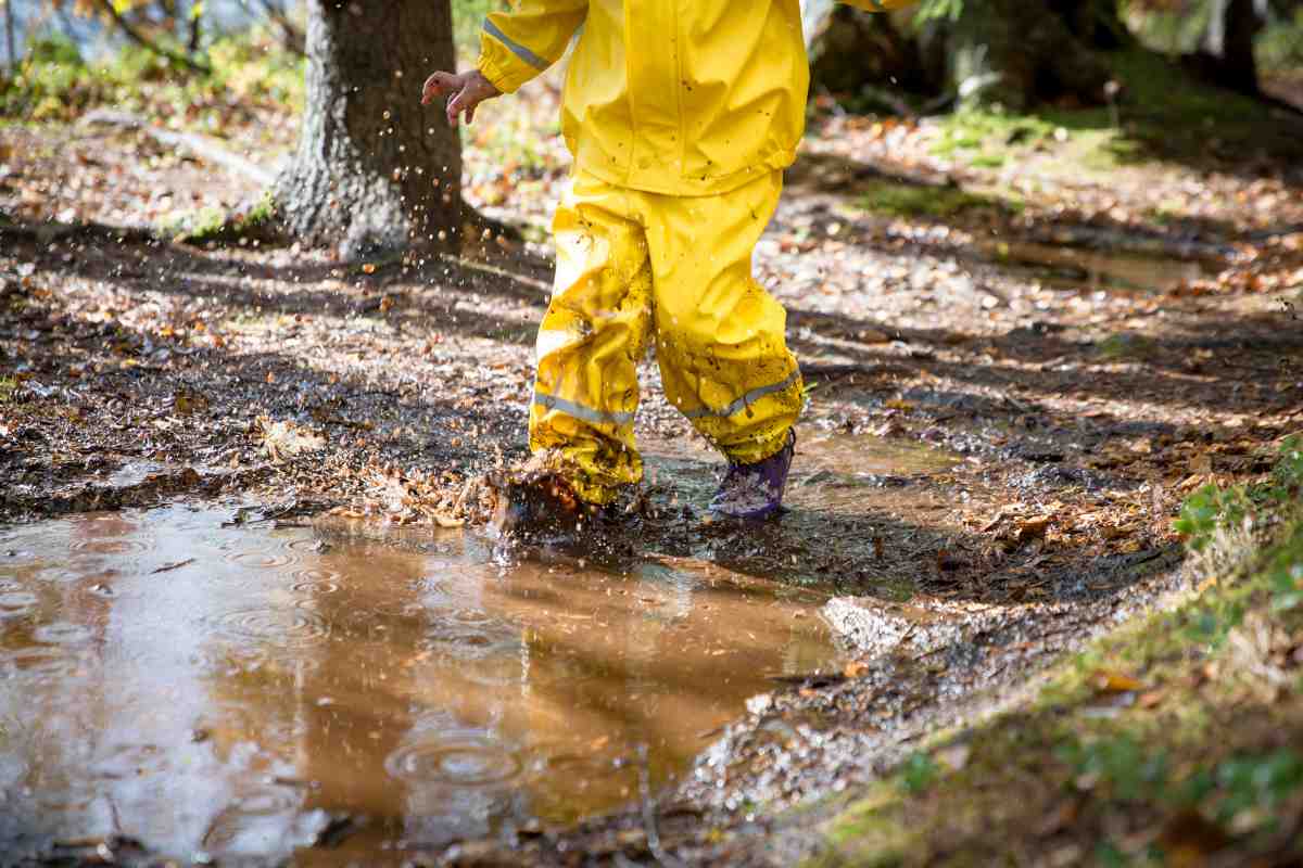 A child stood in a muddy puddle