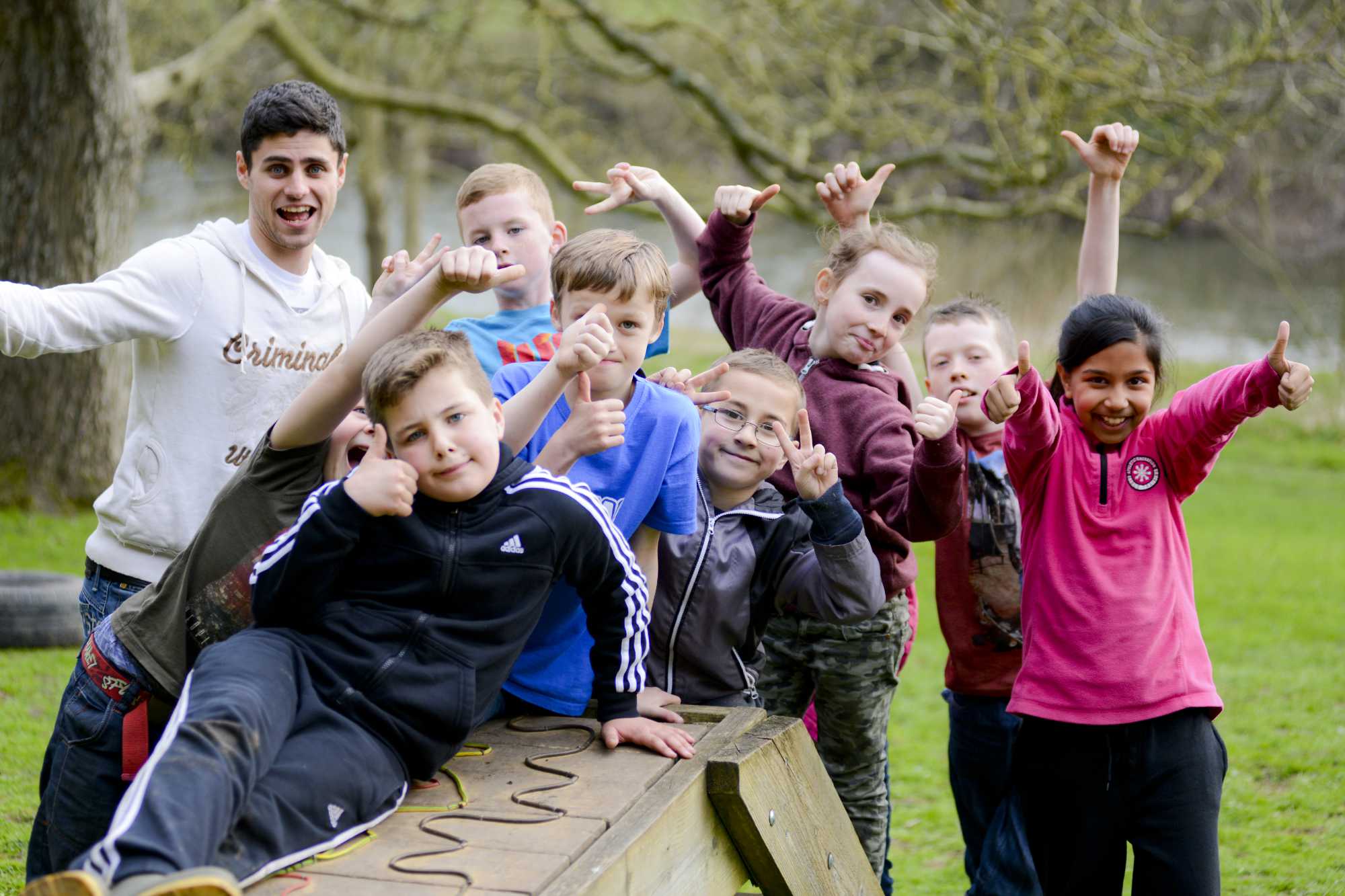 Group of children outdoors with thumbs up