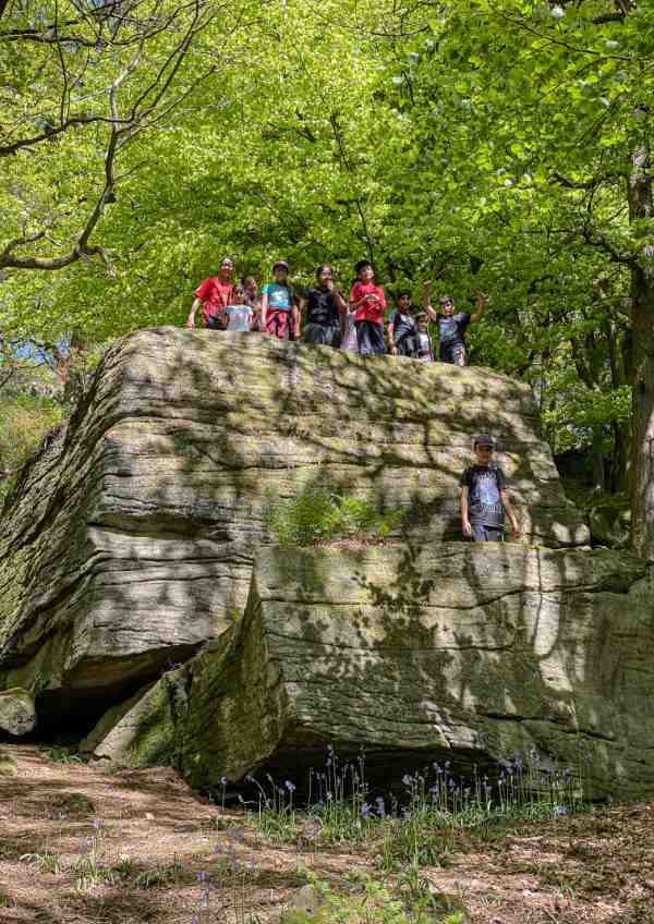 A group of children stood on a big rock