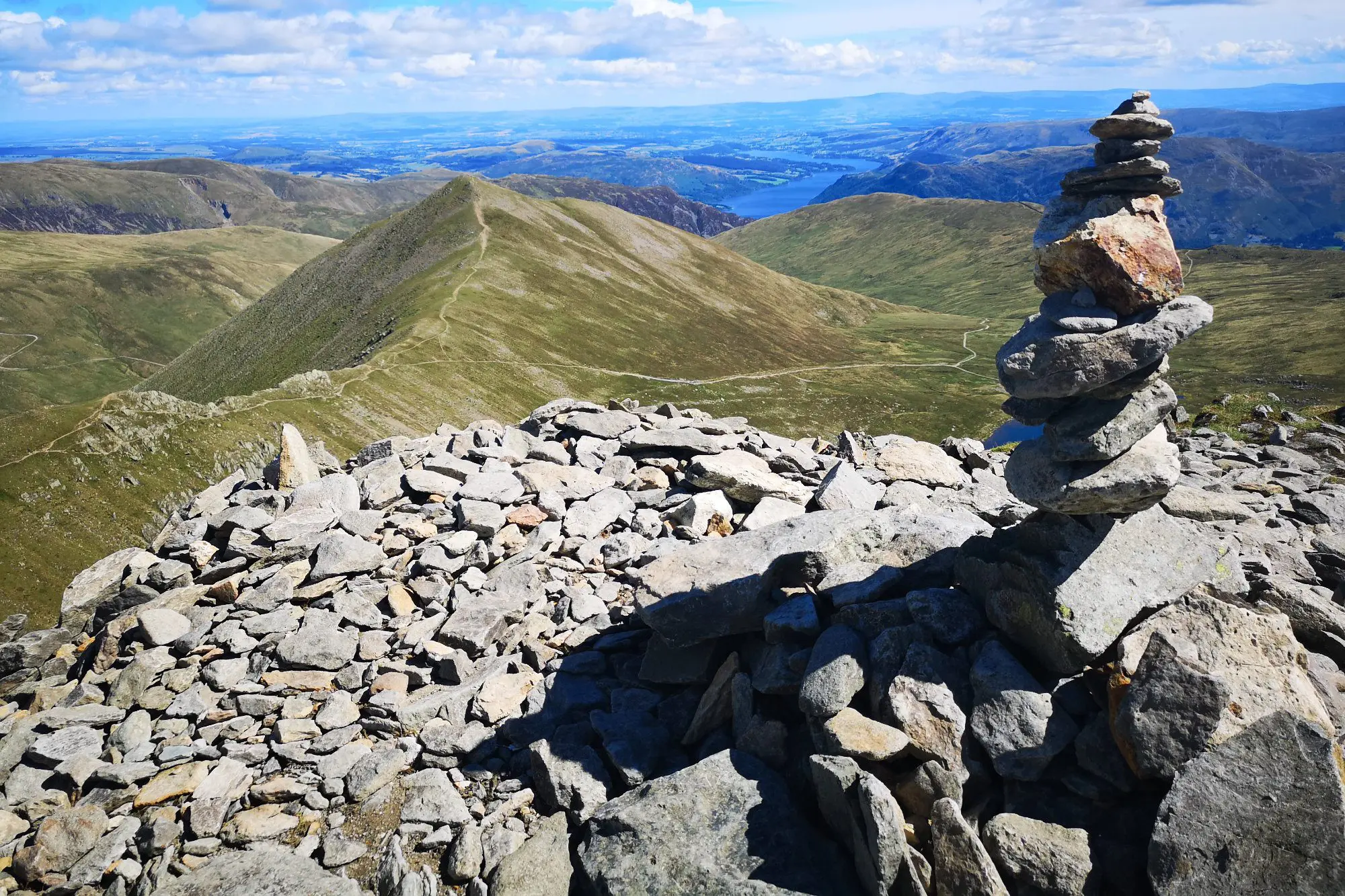 Stack Of Rocks On Helvellyn Summit With Landscape Against Sky