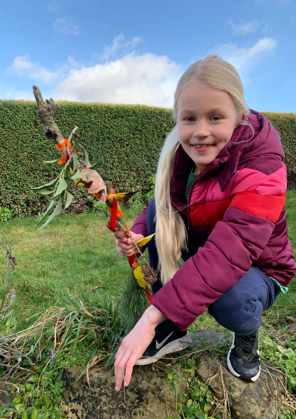 Young girl with journey stick made out of nature