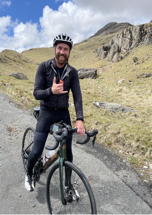 A man smiling on his bike in the Lake District 