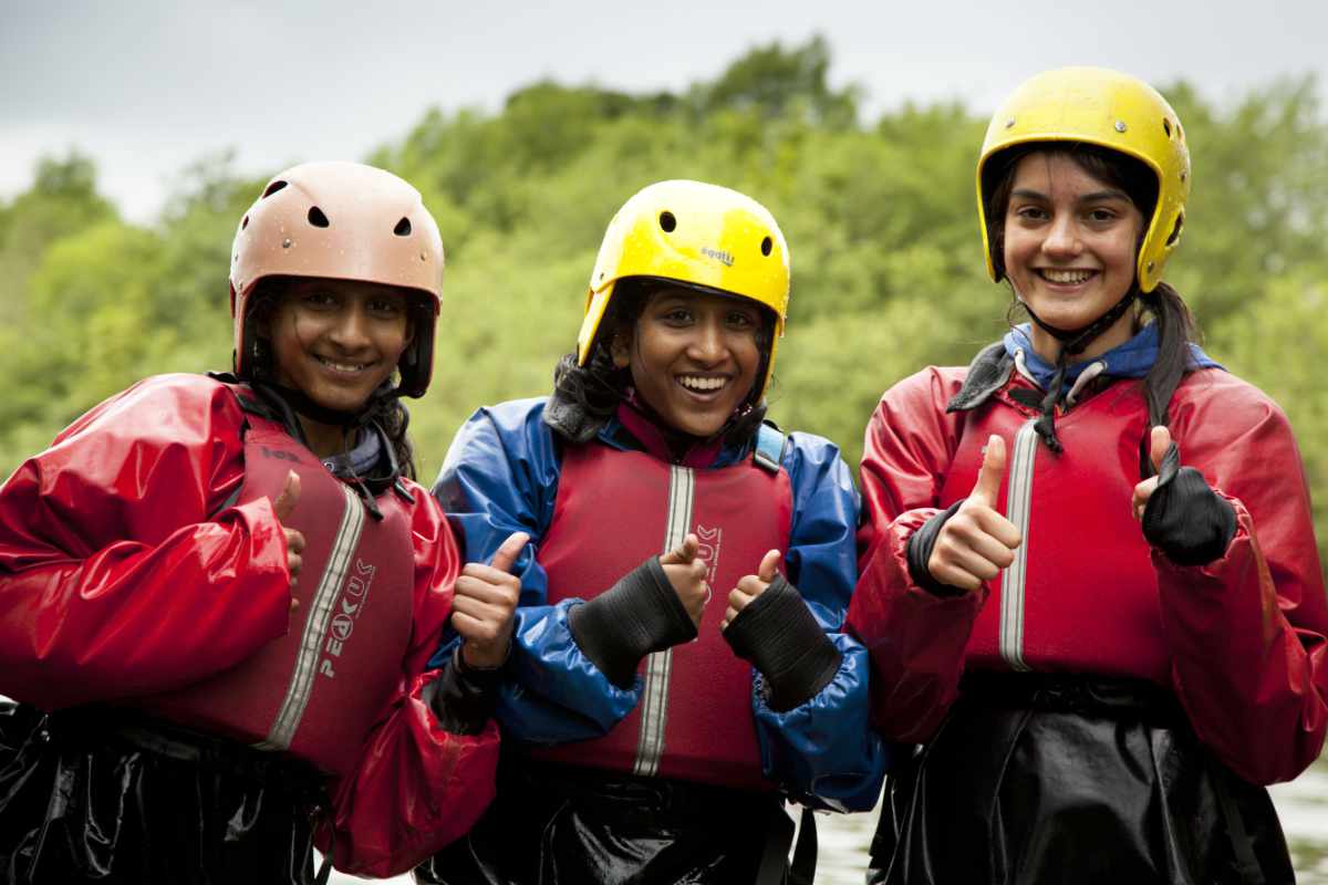 Three girls canoeing on a school trip