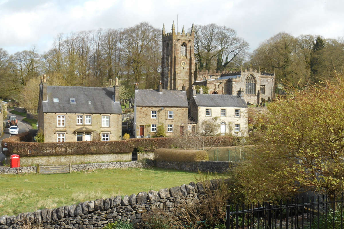 A beautiful peak district village with a church overlooking stone houses